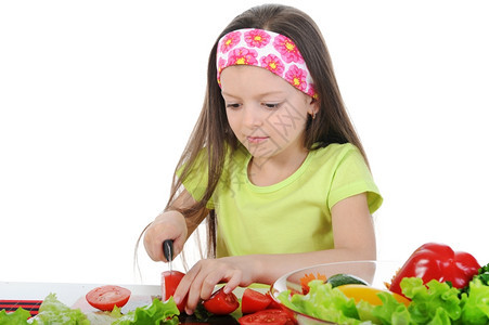 小女孩切新鲜西红柿孤立于白种背景图片