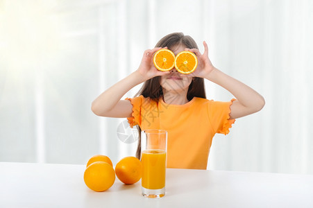 女孩在桌子上橙和果汁图片