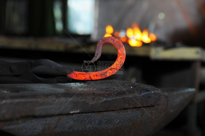 铁匠在铁炉里锻造一个烧红的铁