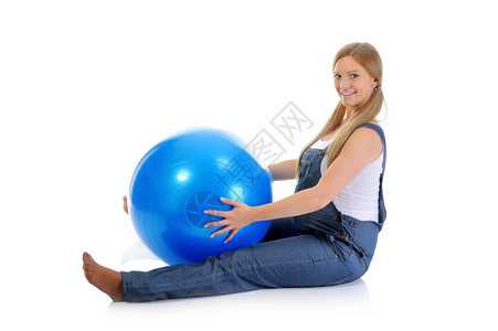 美丽的年轻怀孕少女用蓝色球做运动练习图片