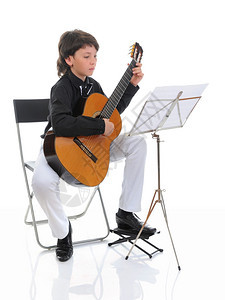 小男孩音乐家玩响吉他孤立在白色背景上图片