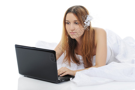 新娘用笔记本电脑躺在地上孤立白色背景上图片