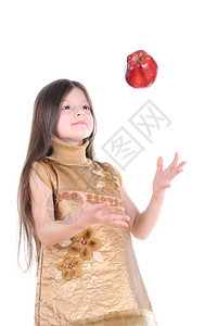 身穿金色洋装的小女孩抓着一个大红苹果孤立在白色背景上图片