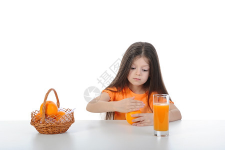坐在桌子上的女孩手握着橙子白种背景的女孩孤立无援图片
