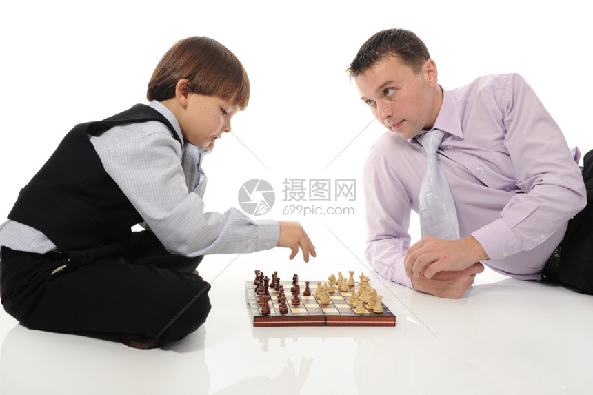 父亲和儿子玩象棋在一个明亮的房间图片