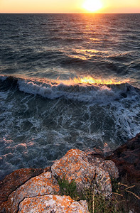 海日落浪和岩石岸图片