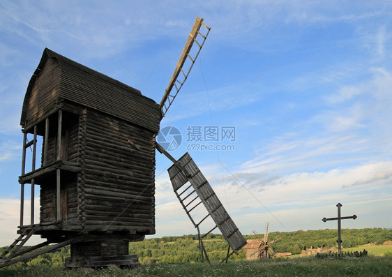 透过旧风车的刀片和过近透风车和乡村建筑观察山谷图片