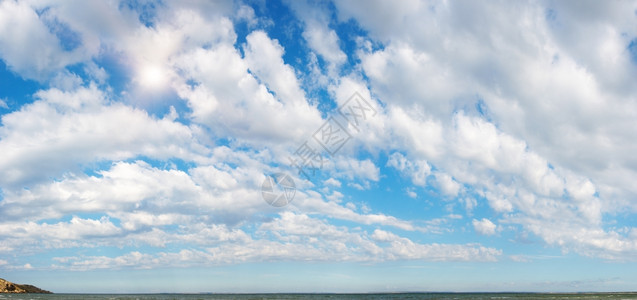 蓝高天空在海面上方有太阳和云四针缝合图像图片