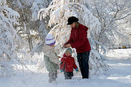 冬季雪覆盖城市公园快乐家庭母亲与小男女孩童图片