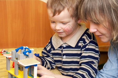 母亲有小儿子在为童建造的筑中玩耍造一栋房子图片