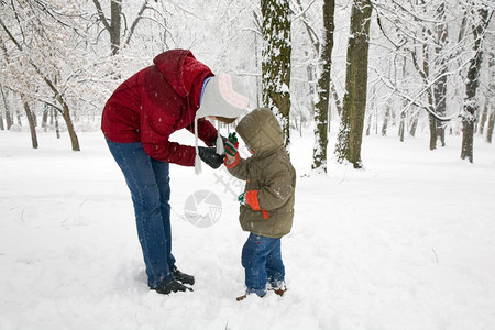 冬季城市公园的幸福家庭母亲和小男孩的图片