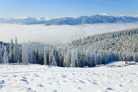 冬季平静的山地景观有些雪覆盖了山地从后面的前线和棚屋群从Bukovel滑雪胜地乌克兰到Svydovets山脊图片