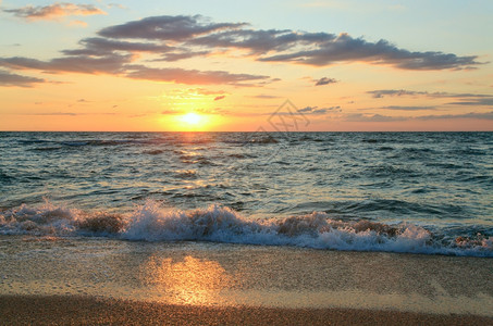 海日夕阳冲浪沙海岸线的大浪断开图片