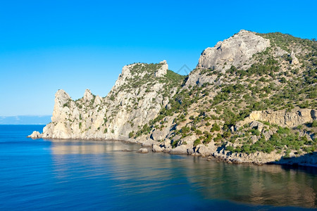 犀牛海夏天的岩石海岸线长着柔树NovyjSvit保留地犀牛斗篷克里米亚乌兰背景