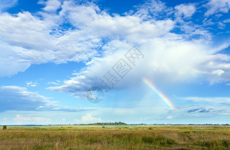夏日草原上方的蓝天白云和彩虹图片
