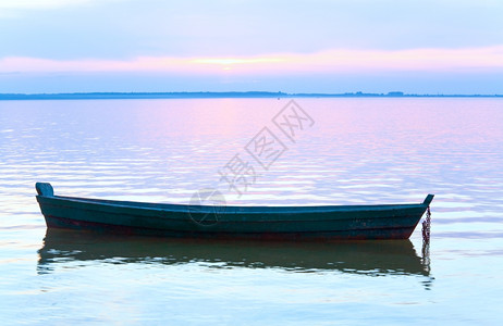 夏季湖岸日落和旧木制渔船乌克兰斯维提亚兹图片
