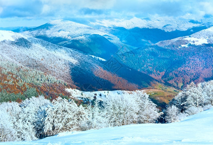 十月山尖森林边缘第一次冬天下雪去年秋在远山边图片