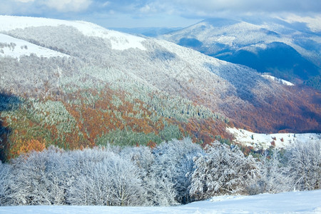 十月山尖森林边缘第一次冬天下雪去年秋在远山边图片