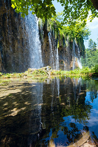 小型纯透明湖泊克罗地亚普利维塞湖公园瀑布的反射图片