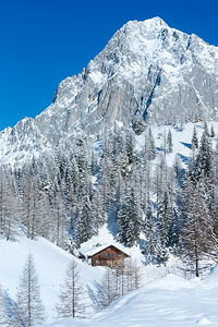 冬天的岩石上面有新的落雪在峡谷里有房子背景图片