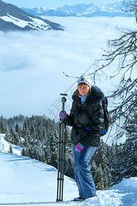 女摄影师和晨冬季山区风景下谷有云奥地利霍科尼希区图片