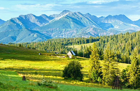 夏季山村郊区附近有谷仓和羊群波兰后面塔特拉山脉图片