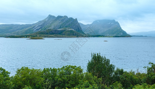 Fjord夏天的阴云前面有树木挪威图片