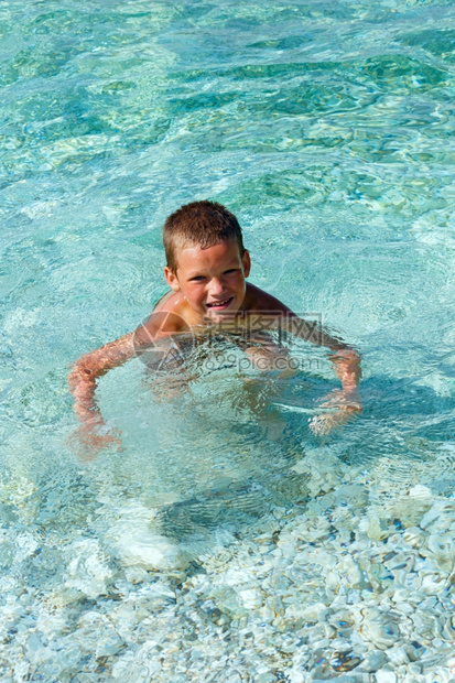 男孩在海里洗澡暑假希腊凯法隆尼亚海滩安提萨莫斯图片