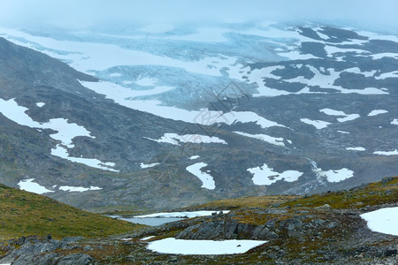 带湖泊和雪的浓雾夏季山地景观挪威不远的尼加德斯布林冰川图片