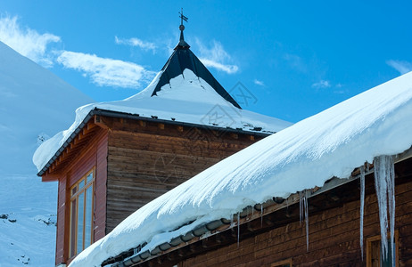 冬季山坡上的木屋顶有雪和冰块背景图片