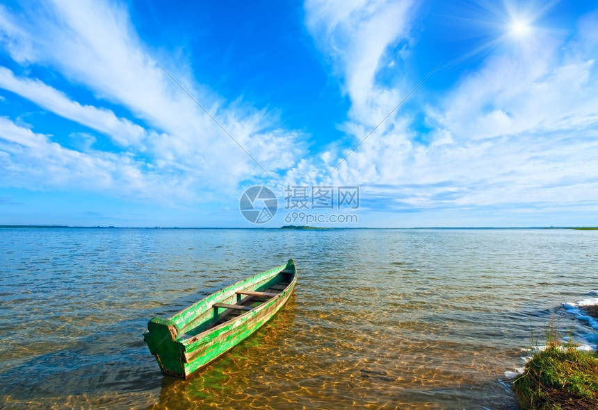 夏季湖岸上的老木式渔船和蓝天上的阳光乌克兰斯维提亚兹图片