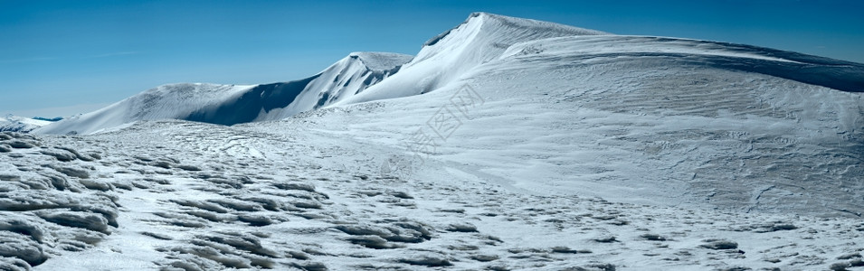 冬季山脉脊上面满是雪帽还有蓝天背景的雪橇脚印乌克兰喀尔巴阡山斯维多茨脉布莱兹尼察山德拉霍布特滑雪胜地图片