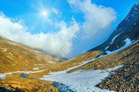 山泉流和太阳靠近Timmelsjoch意大利奥地边界高山公路图片