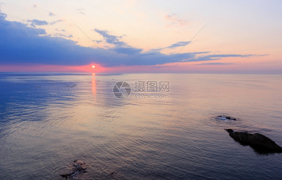 美丽的迷人清晨海景与日出太阳轨道在地表和渔网上图片