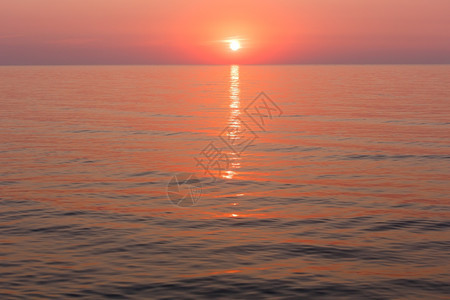 美丽的迷人清晨海景与日出和太阳轨道在表面图片