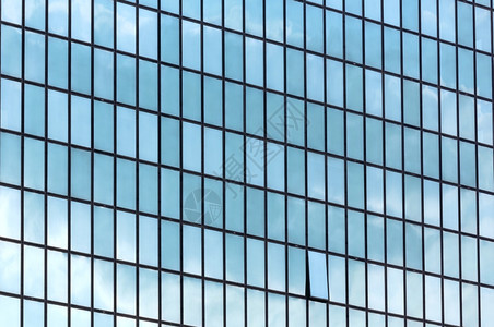 摩天大楼墙上有很多窗户云层反射建筑背景图片