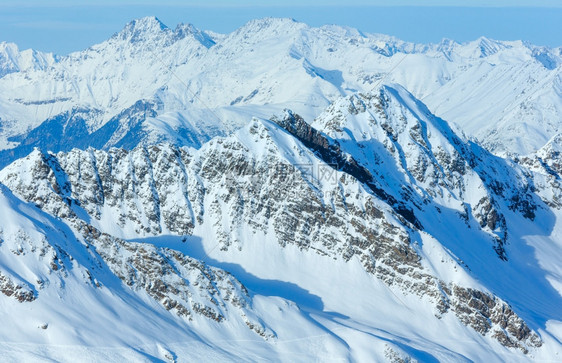 在雪地岩石顶部奥利提洛尔的木屋滑雪升降机上进行冲浪图片