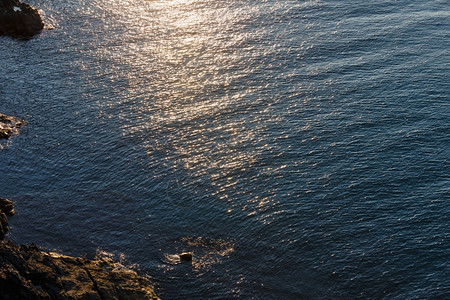 夜晚的海岩岸风景太阳在水面反射图片
