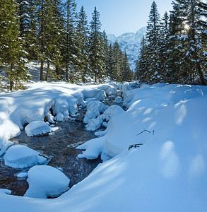 小山流有雪漂在边缘斜坡上有壁树图片