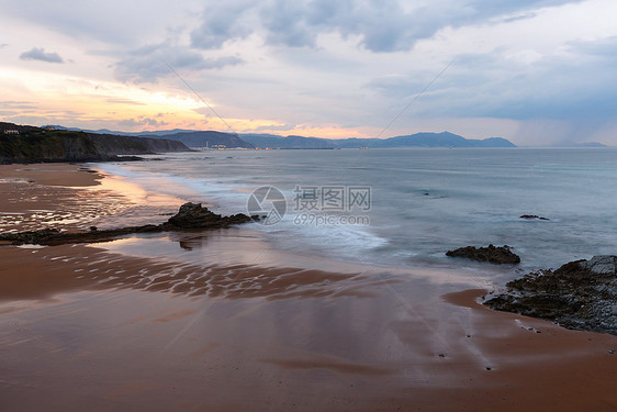 黄昏的海洋岩石岸风景天空反射在沙滩湿上西班牙图片