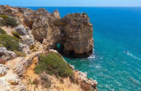 大西洋夏季岩石海岸线PontadaPiedadeLagosAlgarve葡萄牙机动艇上的人无法辨认图片