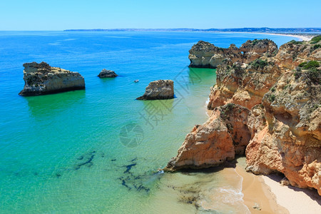 DosTresIrmaos海滩附近的岩石最顶端PortimaoAlvorAlgarve葡萄牙船上的人无法辨认图片