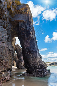 低潮下日光大教堂海滩上的自然岩石拱门坎塔布里克海岸卢戈加利西亚班牙图片