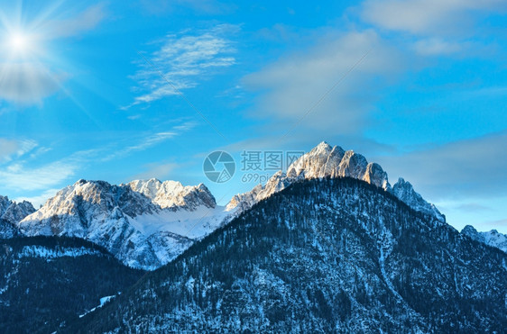 冬季上午阳光明媚的山地景观坡上有森林奥地利图片