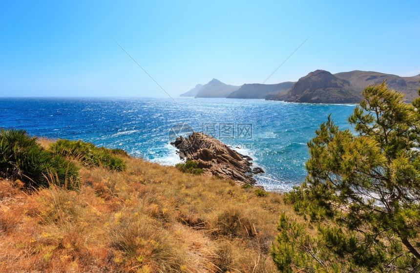 地中海港夏季岸线前面有松树波特曼湾科斯塔布兰卡西班牙图片