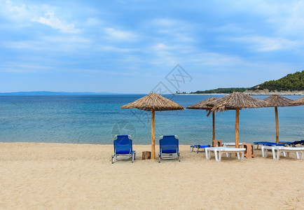 从利图斯海滩锡索尼亚恰基迪希腊的夏季清晨海景中看到有防晒罩和草药遮阳剂的沙滩西图尼亚恰基迪希腊图片