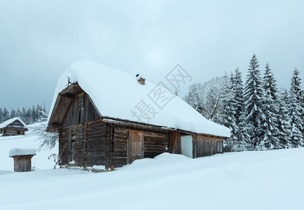冬季乌克兰喀尔巴阡山气候多云坡上雪地滑的木屋图片