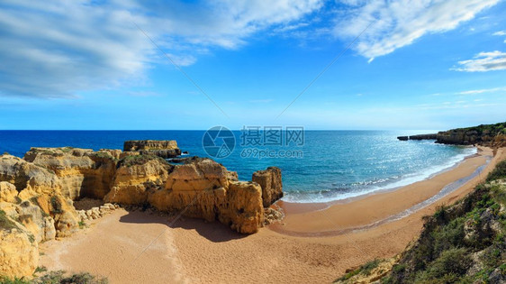 沙滩上的黄色悬崖夏季大西洋岩石海岸顶部阿尔布费拉郊区葡萄牙阿尔加夫和上面的蓝天两针缝合全景图片