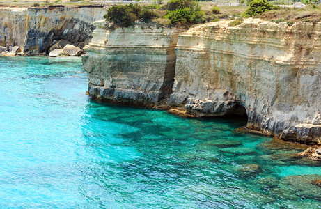 在意大利普亚萨顿海岸TorreSantAndrea的海景中有悬崖和岩石拱门图片