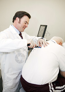 Chiropractor使用电脑工具调整病人背部图片